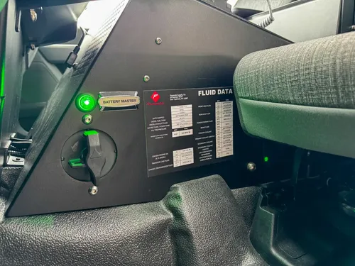 Lower center-console close-up with cup holder, coiled mic, and panel face.